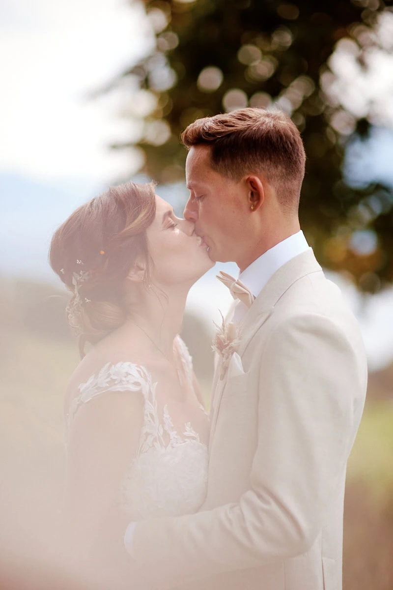 Couple de mariés s’embrassant tendrement dehors