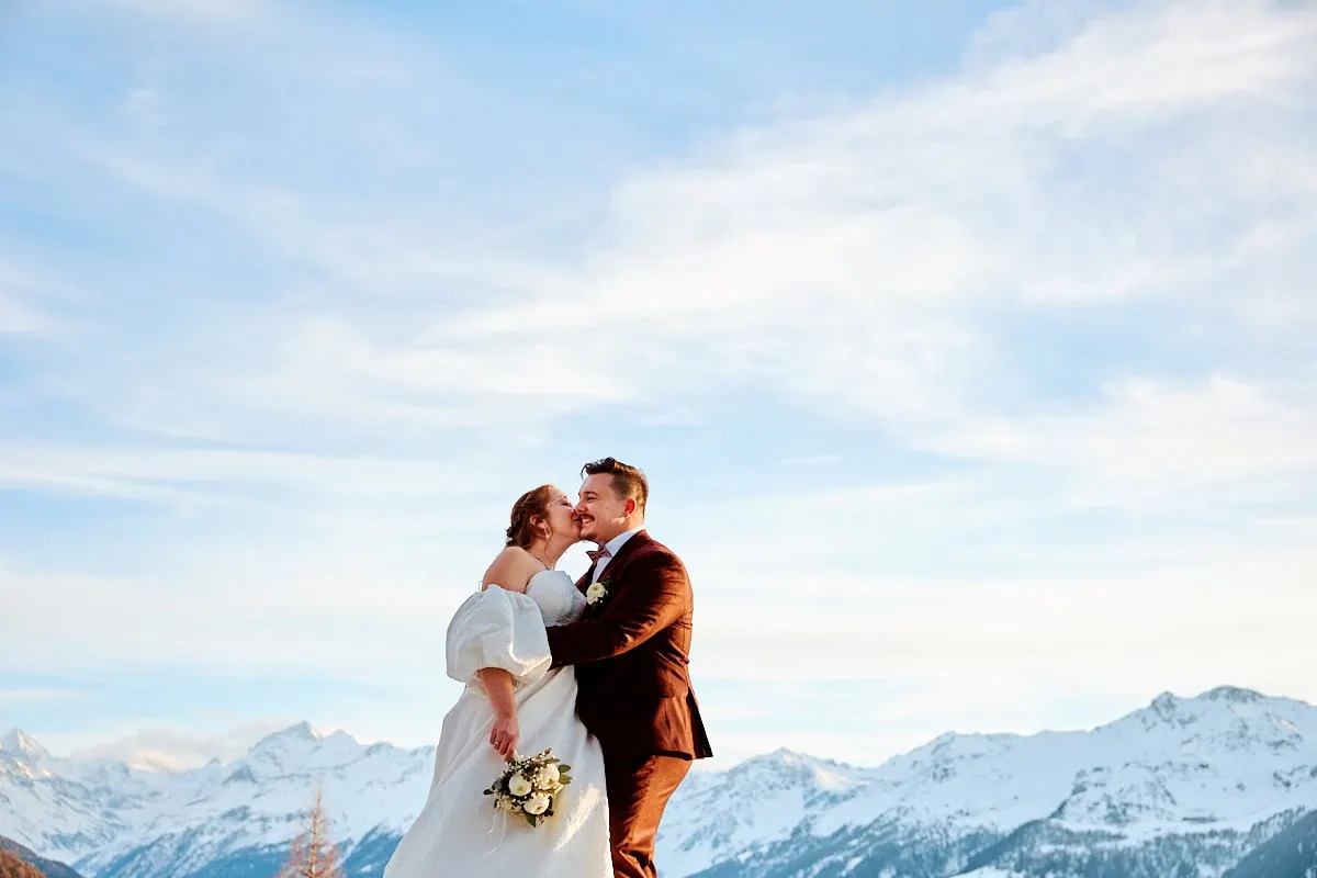 Couple de mariés devant montagnes enneigées