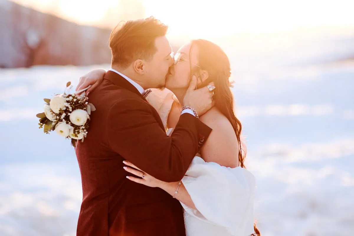 Couple de mariés s’embrassant sous la neige