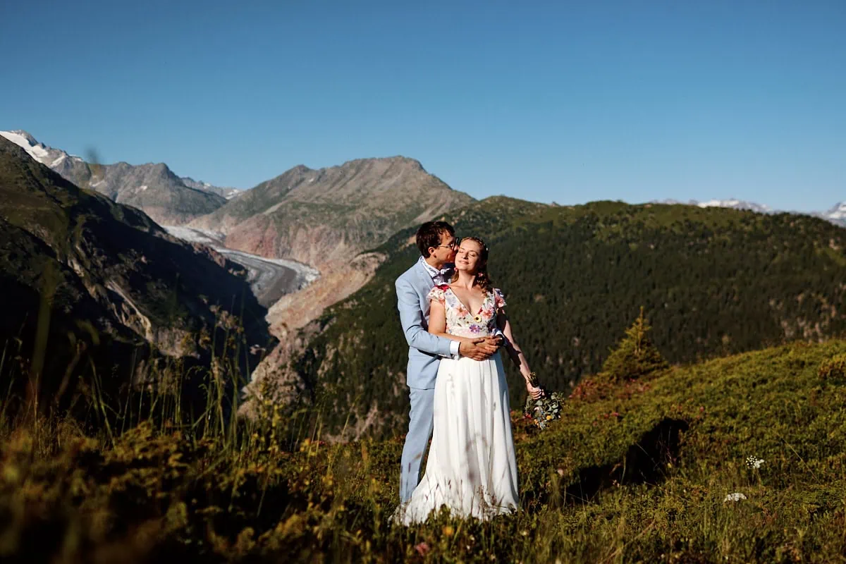 Couple marié s’embrassant dans la montagne.