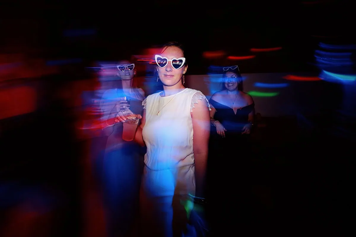 Personnes dansant avec lunettes cœur en soirée colorée