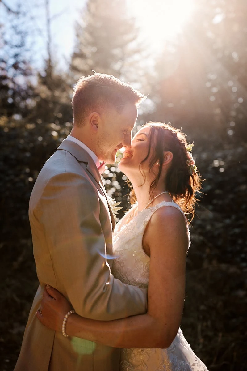 Couple de mariés s’embrassant au soleil