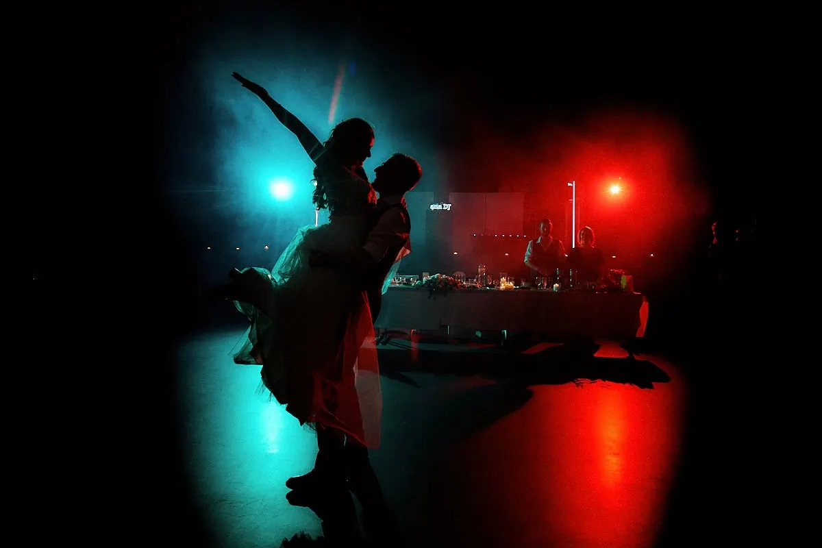 Couple dansant sous lumières rouges et bleues.