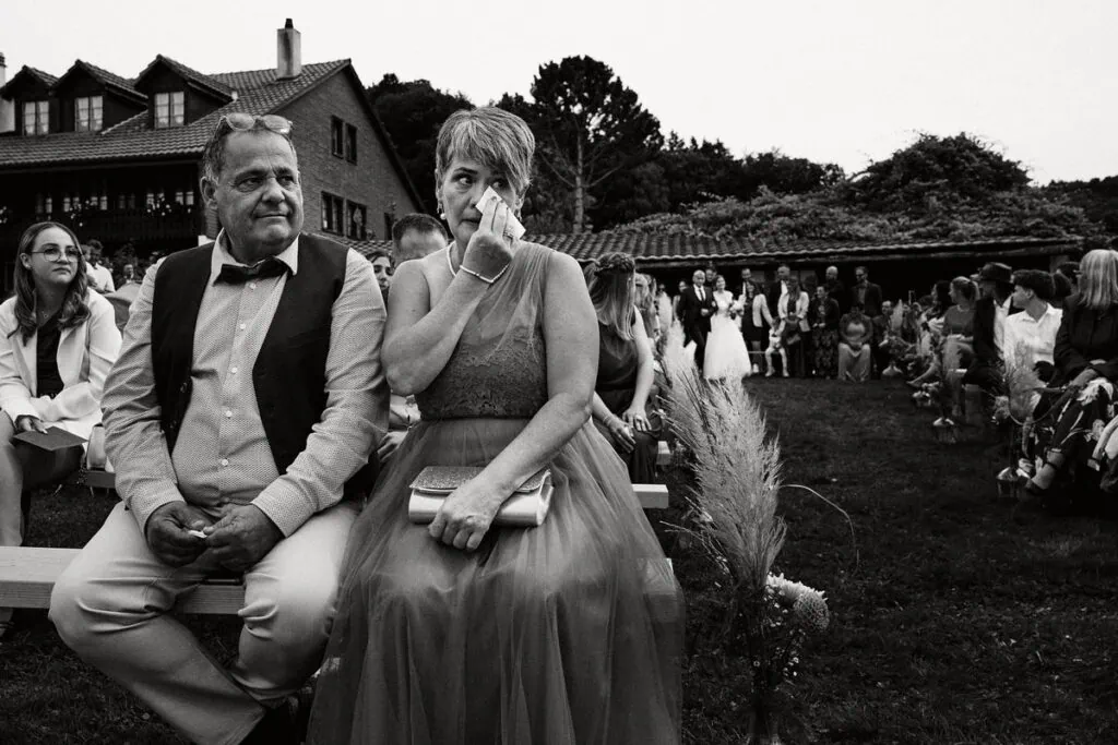 Photo de mariage en plein air avec invités et couple heureux.