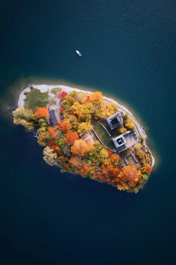 Îlot automnal entouré d’eau avec bateau