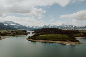 Lac alpin entouré de montagnes enneigées et village