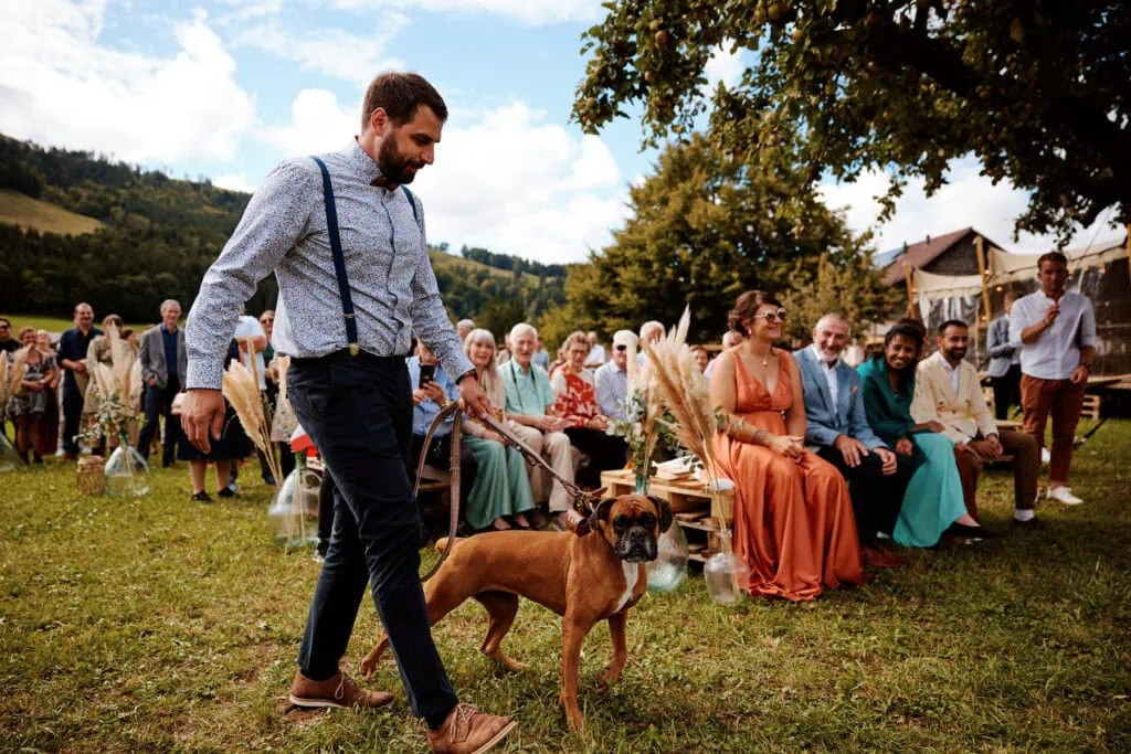 Homme promenant un chien à un mariage champêtre