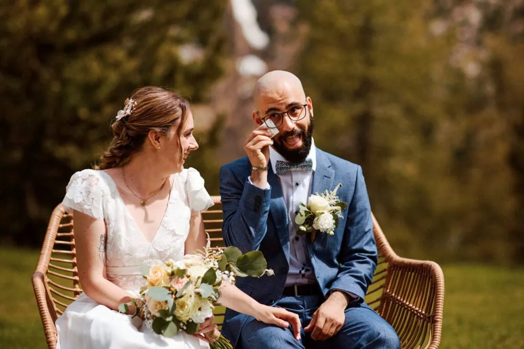 Mariés assis, marié ému essuyant une larme