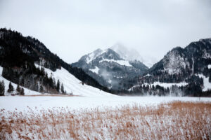 Montagnes enneigées et lac gelé dans la brume