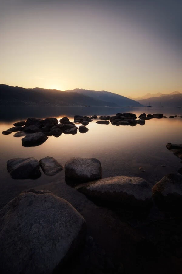 Coucher de soleil sur lac et montagnes
