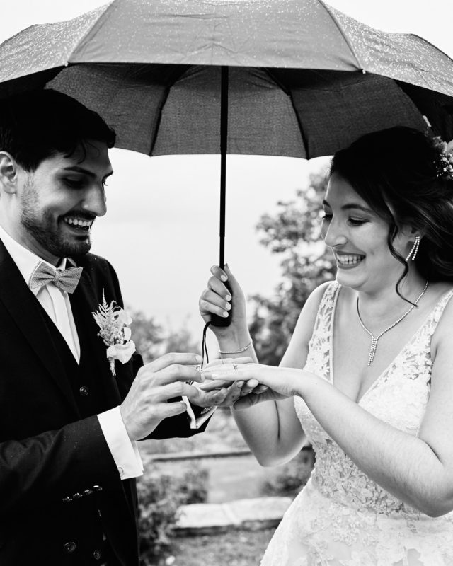 Il pleut le jour de ton mariage… et alors ? 

Tu redoutes la pluie le jour de ton mariage ? Rassure-toi tout de suite : tu n’es pas le ou la seul·e ! Les jours précédant un mariage, je me transforme en véritable météorologue, obsédé par MeteoSwiss ou LandiMeteo, selon celle qui annonce le plus beau temps, évidemment.

Je ne t'apprends rien, la météo c'est le seul point que tu ne peux pas prévoir et décider pour ton mariage.
Mais bonne nouvelle : c’est loin d’être une catastrophe.

Personnellement, je préfère même un temps légèrement couvert, avec de jolis nuages dans le ciel. Visuellement, ça rend super bien en photo. Un ciel chargé de nuages adoucit la lumière, évite les ombres marquées sur les visages et surtout… pas d’yeux plissés à cause du soleil !

Alors oui, un ciel bleu avec un grand soleil, je ne crache pas dessus non plus mais j'aime bien les nuages ! 

Et la pluie ? Si on peut l’éviter, c’est top. Mais parfois, il faut faire avec.

Que vous décidiez de maintenir la cérémonie sous quelques gouttes ou de faire vos photos de couple sous la pluie : je suis toujours partant. Quitte à me tremper, c’est pas grave j’ai toujours une chemise de rechange dans la voiture !

La pluie amène une ambiance, tout le monde s'en souviendra ! Il a neigé en mai il y a 6 ans, je m'en souviens sur quel mariage c'était et où j'étais pourtant depuis j'en ai vécu des mariages pluvieux ! 

Mais le pire avec la pluie c'est que tout le monde vous dira "Mariage pluvieux mariage heureux" alors qu'à l'origine c'est "Mariage plus vieux, mariage heureux !". Mais bon s'il fait beau vous aurez droit à "Vous avez de la chance avec le temps hein !" (à dire avec l'accent fribourgeois, ça sonne mieux)

 #mariage #mariagesuisse #mariagesuisseromande #pluie #mariagepluvieux #fribourg #vaud #photographe #photographer #photographemariage #photographeprofessionnel #photographesuisse #photographesuisseromande